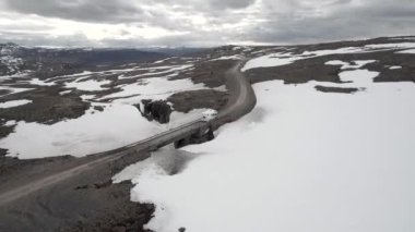 Boş bir karlı yolda ilerleyen bir karavan karavanı. 