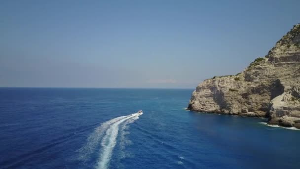 ギリシャの海岸線難破船ビーチジェットボートトウモロコシの周りの日当たりの良い白い崖 — ストック動画