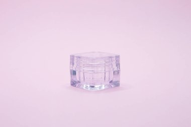 Pembe arka planda boş kozmetik kavanozu