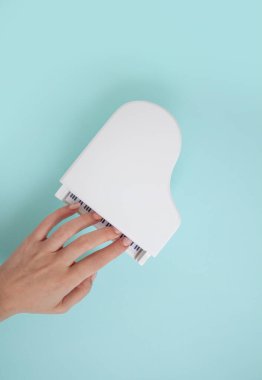 Turkuaz arka planda eli olan oyuncak beyaz büyük piyano.