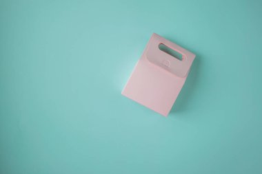 Turkuaz arka planda pembe kağıt hediye paketi