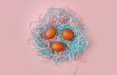 Pembe arka planda renkli yuvalarda paskalya yumurtaları