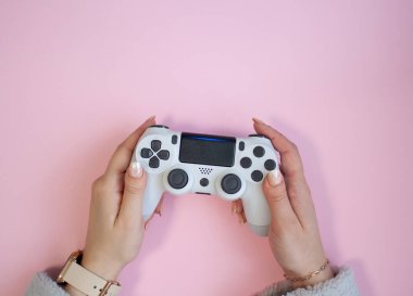 Pembe arka planda beyaz bir oyun alanı tutan eller