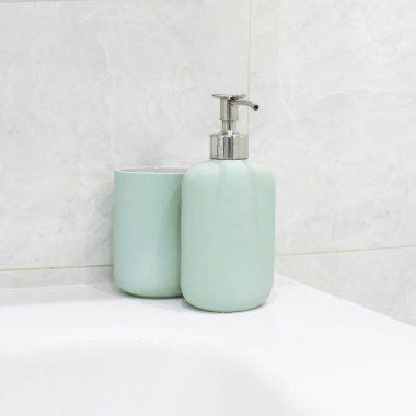 Beyaz lavabo ve mermer duvarda naneli banyo dekoru.