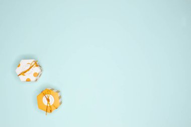 Turkuaz arka planda iki altın hediye kutusunun düz düzeni.