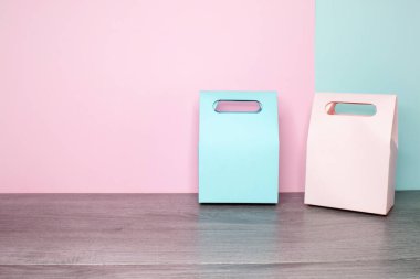 İki kağıt hediye çantasına pembe ve mavi bir bakış açısı. Arka planda pembe ve nane arkaplanı.  