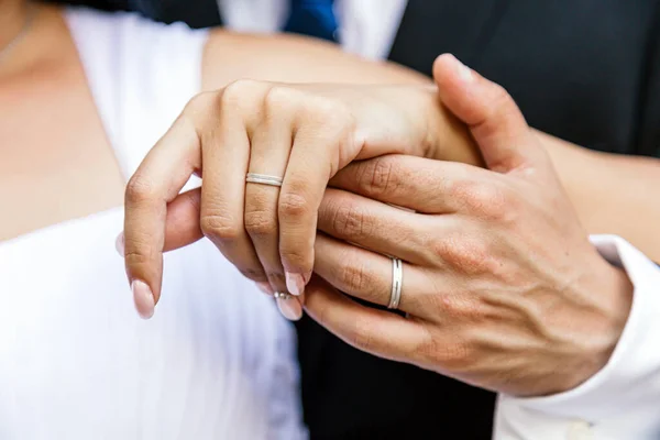 Close up of the hands of a just married couple showing their rings in their wedding day