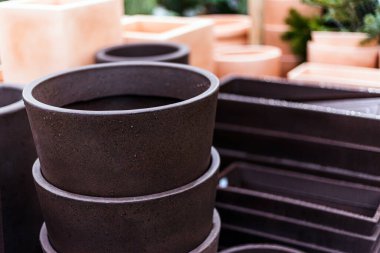 Bir bahçe merkezindeki basit siyah çömlekleri kapatın.