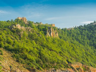 Alanya, Türkiye. Kleopatra sahilinden dağdaki antik Alanya Kalesi 'nin güzel manzarası. Tatil kartpostal arkaplanı