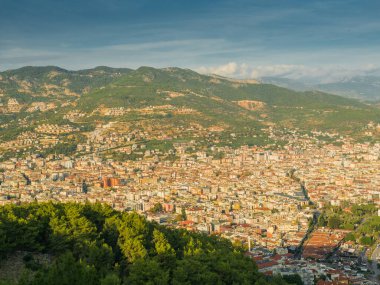 Alanya, Türkiye. Alanya şehrinin Alanya Kalesi 'nden gün batımında dağların arka planında güzel bir manzara. Tatil kartpostal arkaplanı