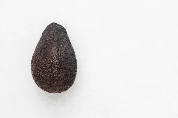 Fruta entera de aguacate marrón maduro sobre fondo blanco. Grasas saludables. Vista superior, espacio de copia —  Fotos de Stock