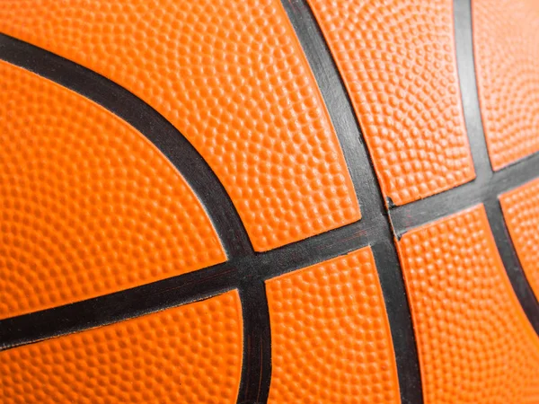 Orange basketball ball close up. Fragment, black stripes, texture. Sport geometric background