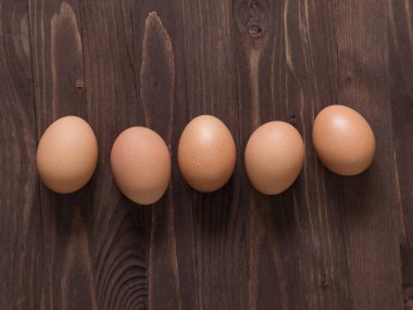 Ahşap arka planda turuncu tavuk yumurtası. Paskalya konsepti. Minimalizm. Üst Manzara. Boşluğu kopyala.