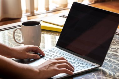 Oturma odasında elinde defterle evden çalışan bir kadın.