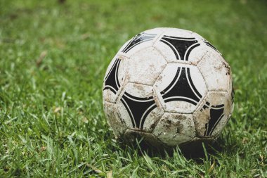 Islak çimlerde eski futbol topu