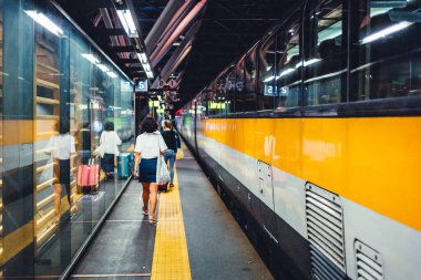 İnsanlar tren istasyonundan ayrılmaya hazırlanıyor.