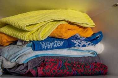 Rafta renkli parlak havlular yığını