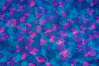 Tekstil üzerine küçük menekşe, pembe ve mavi kalplerden oluşan arkaplan