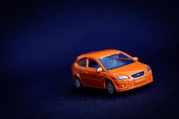 closeup view of orange toy car on dark background