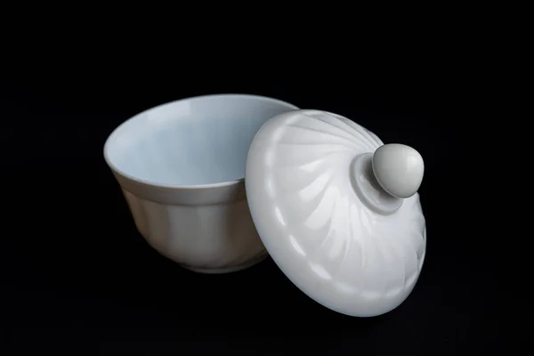 White empty sauce boat with the cover on dark black background