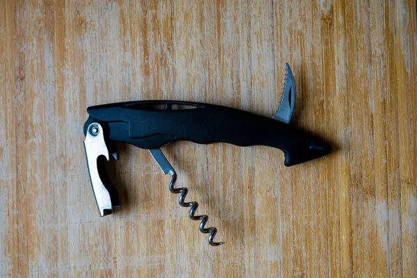 siyah plastik ve metal şişe açacağı ahşap kesim tahtasında, üst manzara