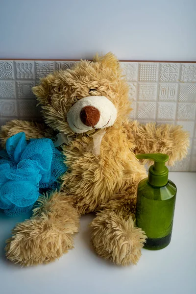 Jasnobrązowy Miś Siedzący Zieloną Plastikową Butelką Mydła Mycia Rąk Niebieskiej — Zdjęcie stockowe