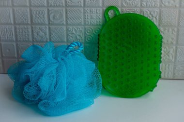 Beyaz arka plandaki banyoda mavi ağ fırçası ve yeşil cilt fırçasının yakın görüntüsü