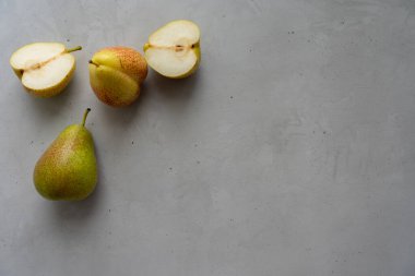 Beton zeminin sol üst köşesinde iki armut ve iki armut var.