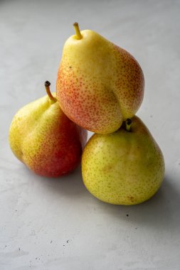 Beton yüzeyde üç büyük olgun armut grubu.