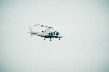 Bulanık gökyüzünde beyaz helikopter