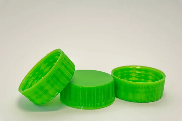 green plastic bottle stoppers on a white background