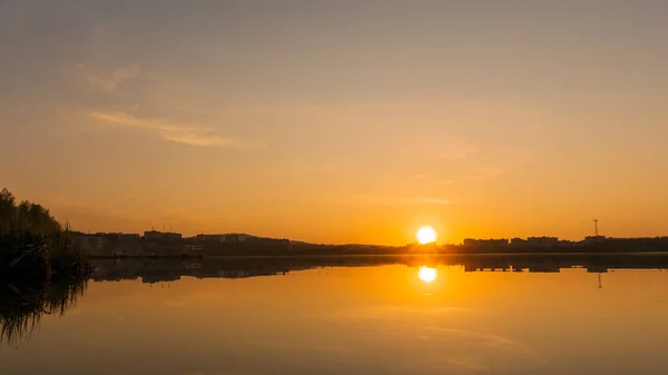 街の近くの湖に沈む夕日 — ストック写真