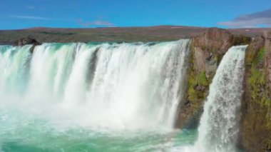 Gökkuşağıyla Godafoss Şelalesi üzerinde uçan bir uçak.