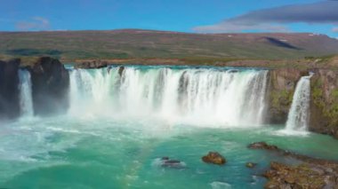 Gökkuşağıyla Godafoss Şelalesi üzerinde uçan bir uçak.