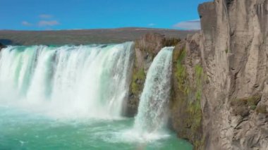 Gökkuşağıyla Godafoss Şelalesi üzerinde uçan bir uçak.