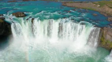 Gökkuşağıyla Godafoss Şelalesi üzerinde uçan bir uçak.