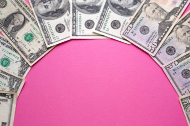 Pembe arka planda dolar banknotları. Kadın maliyeti. Uzayı metin için kopyala. Bankada döviz kuru.