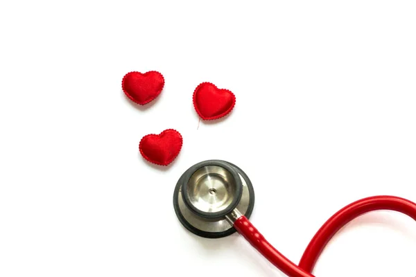 Diagnosis and treatment in cardiology. Medicine concept - Close up red stethoscope and hearts isolated on white background. Copy space for text.