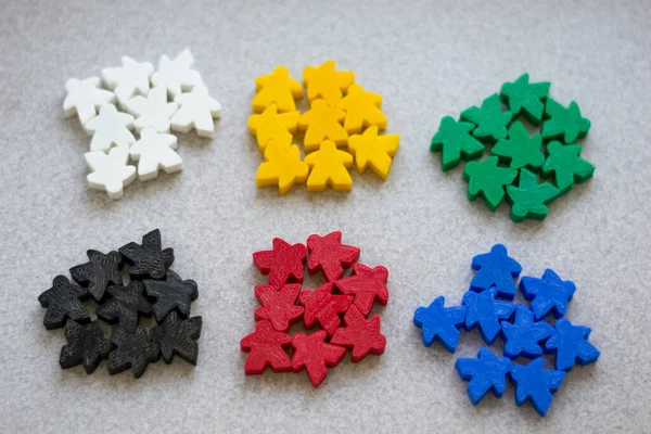 Groups of colorful meeples isolated on gray background. Blue, red, black, green and yellow. Small figures of man. Board games concept. . Business strategy. Components of card games.