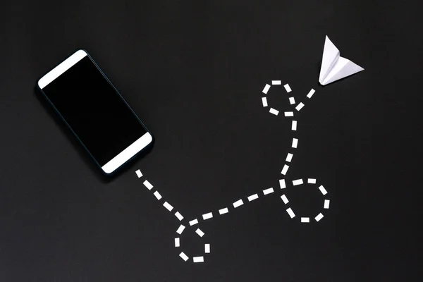 紙のメッセージは 黒の背景にスマートフォンを持つユーザーのために送信されます 家族や友人との無線通信 — ストック写真