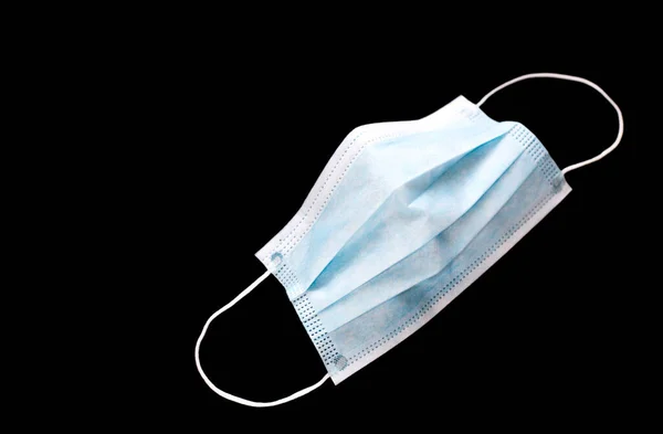 Tıbbi koruyucu kişisel maske siyah arka planda izole edilmiş. Covid-19 salgınına karşı koruma ve önleme kavramı. Salgın, hastane, karantina, izolasyon, eksiklik sorunu.