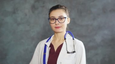 Doktor kadın portresi baş parmağını aşağı gösteriyor, olumsuz bir ifadeyle bakıyor, onaylamıyor..
