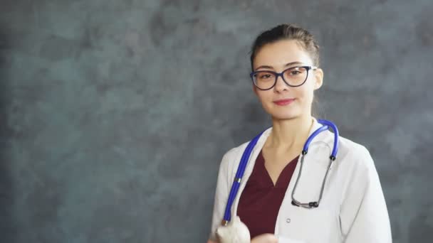 Vrouwelijke dokter die geld in de spaarpot stopt. Begrip ziektekostenverzekering — Stockvideo