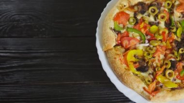 Siyah ahşap arka planda geleneksel sebzeli pizza, kopyalama alanı. Vejetaryen yemeği. Çevirme videosu