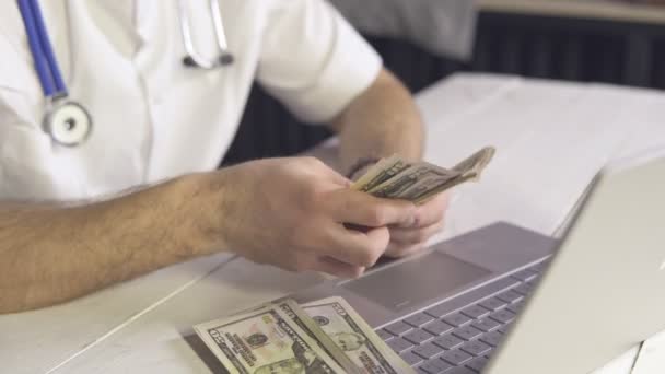 Primo piano del medico che conta le banconote in dollari. Concetto di corruzione o assistenza sanitaria costosa — Video Stock