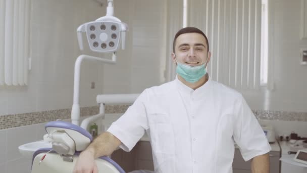 Portrait de dentiste heureux portant un masque chirurgical dans une clinique dentaire — Video