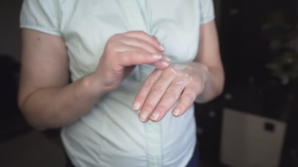 Detailní záběr starší ženy použití hydratační krém na ruce doma — Stock video