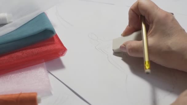 Dressmaker ritar en modeskiss. Närbild av händerna med gummi — Stockvideo