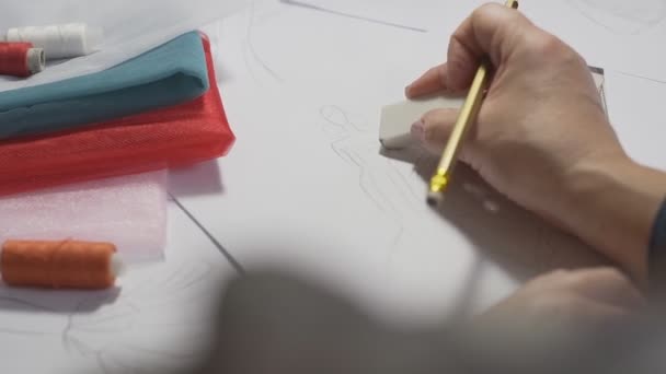 Kvinnlig modedesigner gör skisser. Närbild av sömmerska händer med gummi — Stockvideo