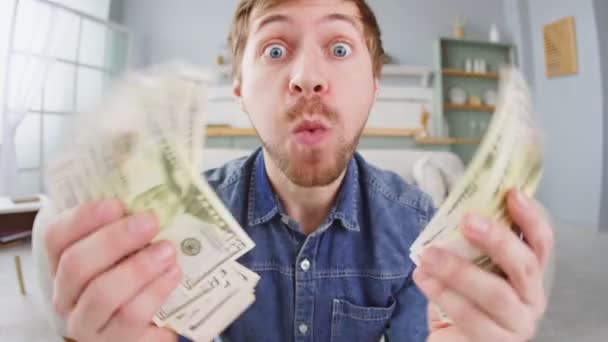 Portret van een opgewonden jongeman met veel bankbiljetten en feestvieren — Stockvideo